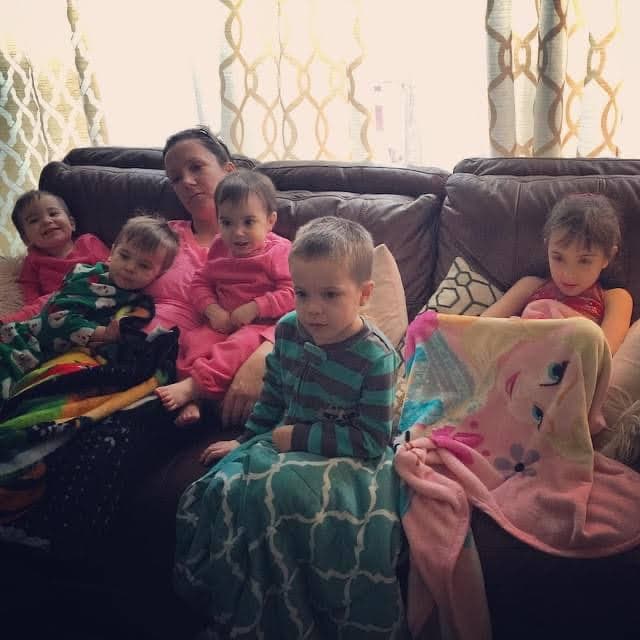 Meg Miller and her five young children watching TV on the couch