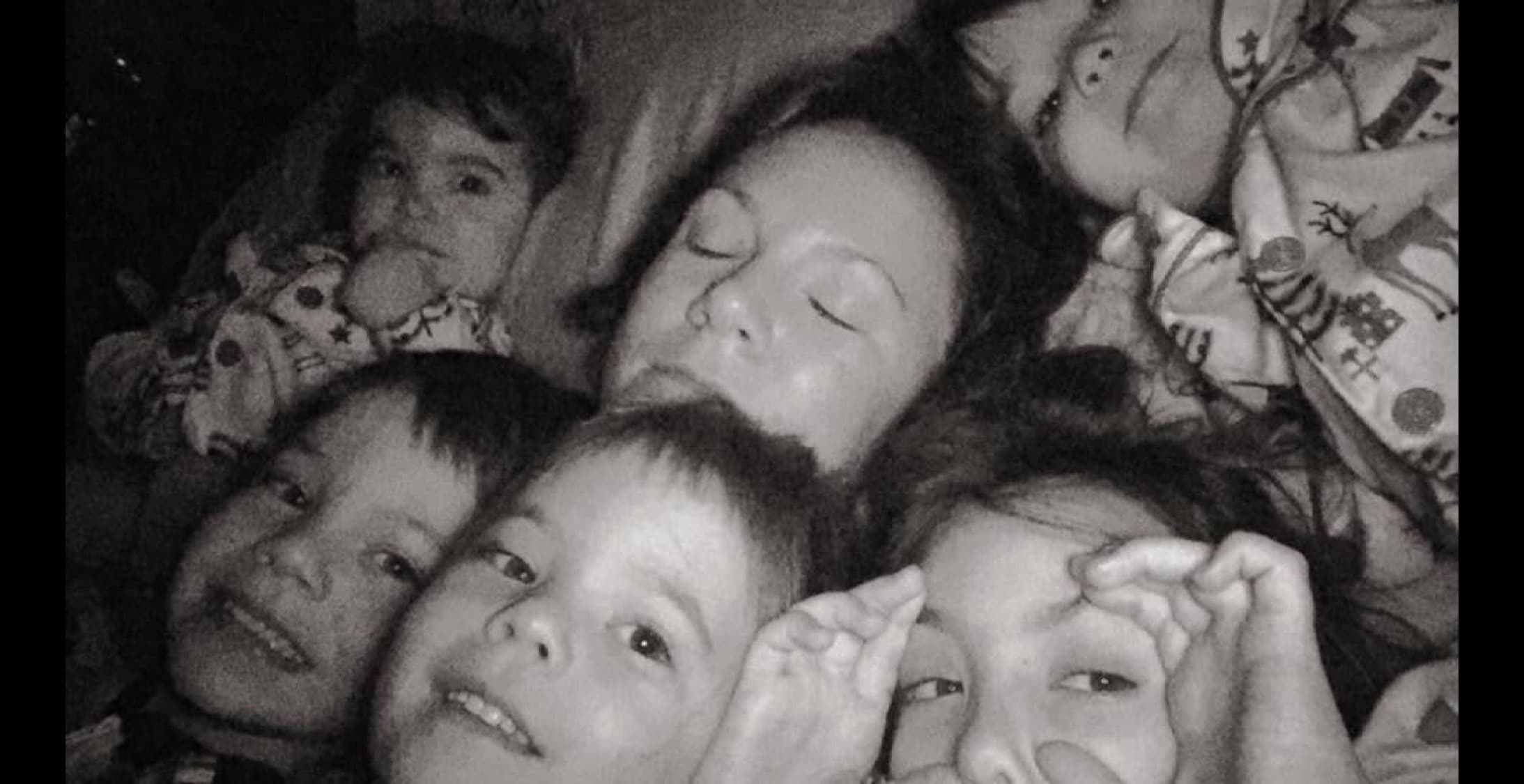 Black and white photo of Meg Miller and her children snuggling